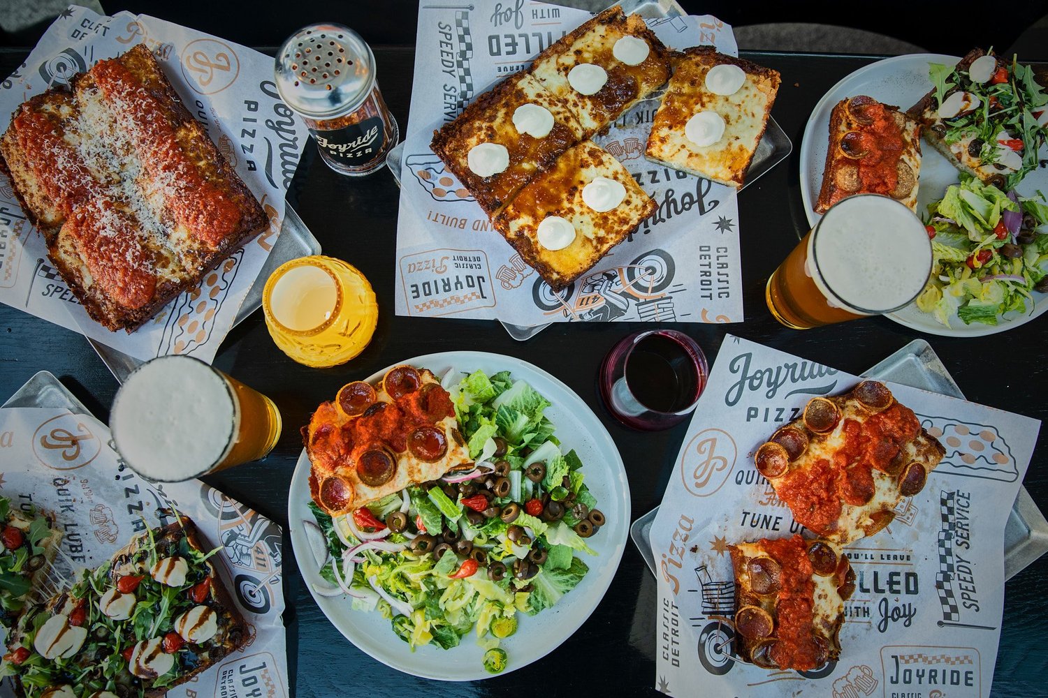 Guests celebrating together with pizza and drinks at a Joyride Pizza event